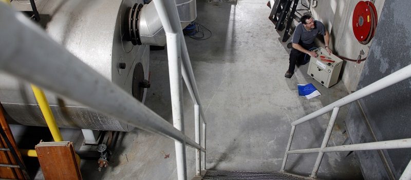 Controle van een keerklep door een Hydroscope medewerker in de kelder.