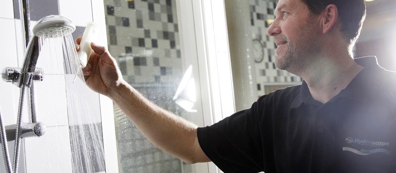 Medewerker Hydroscope meet de temperatuur van de douche