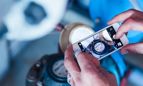 Medewerker maakt een foto van een watermeter dit helpt bij duurzaam watergebruik